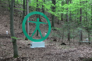 Station 8: Sonnengeflecht und gesprungener Stütz Bild zeigt die Erlebnisstation 08: Eingekreiste lebensgroße Statue die den Umriss vom Menschen darstellen soll.